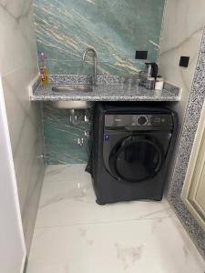 a washing machine in a bathroom under a sink at Luxury king studio in 6th Of October