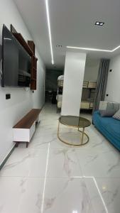 a living room with a table and a tv on a wall at Luxury king studio in 6th Of October