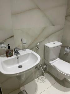 a white bathroom with a toilet and a sink at Luxury king studio in 6th Of October