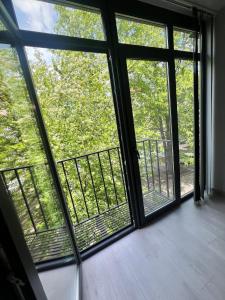a room with three windows with a view of trees at Komarova in Chernivtsi