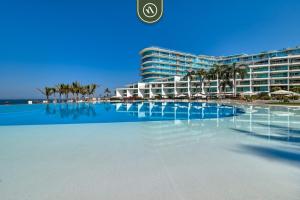 a large swimming pool in front of a hotel at Ocean view 2BR Condo - Private Terrace - Beach in Nuevo Vallarta