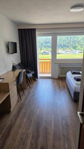a hotel room with a bed and a desk at Naturparkhotel Florence in Weissenbach am Lech