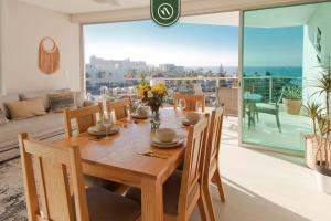 a dining room with a wooden table and a large window at Ocean view 2BR Condo - Private Terrace - Beach in Nuevo Vallarta