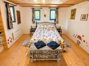a bedroom with a bed and a wooden floor at Csigaház Vendégház in PerÅ‘csÃ©ny