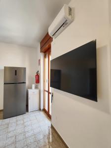 a kitchen with a refrigerator and a television on the wall at baia verde holiday in Baia Verde