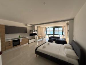 a bedroom with a bed and a kitchen and a living room at Angolina Apartments in Birżebbuġa