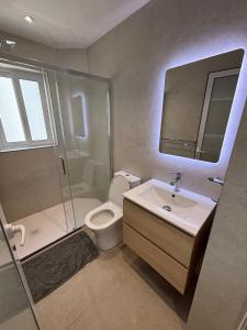 a bathroom with a toilet and a sink and a shower at Angolina Apartments in Birżebbuġa +31 photos