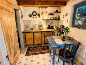 a kitchen with a table and a sink at Csigaház Vendégház in PerÅ‘csÃ©ny