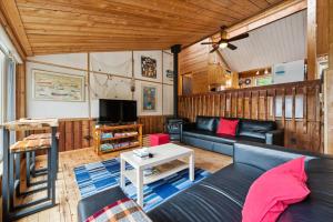 a living room with a couch and a tv at Rustic Waterfront Kayak Near National Park in Tobermory