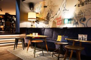a couple of tables and stools in a restaurant at Ruby Marie Hotel Vienna by IHG in Vienna