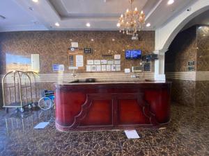 a bar in a lobby with a chandelier at شقق برج أربعين واحد in Al Qurayyat