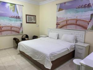 a bedroom with a bed and a large window at شقق برج أربعين واحد in Al Qurayyat