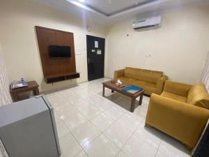a living room with two couches and a tv at شقق برج أربعين واحد in Al Qurayyat