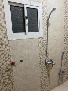 a bathroom with a shower with a window at شقق برج أربعين واحد in Al Qurayyat +6 photos