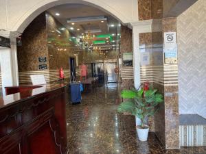 a lobby with a bar and a potted plant at شقق برج أربعين واحد in Al Qurayyat