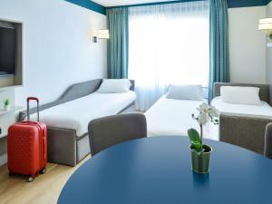 a living room with a red suitcase in a hotel room at Aparthotel Adagio Monaco Palais Joséphine in Beausoleil