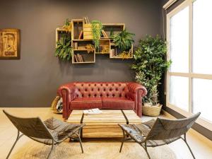 a living room with a red couch and chairs at Ibis Oviedo in Oviedo