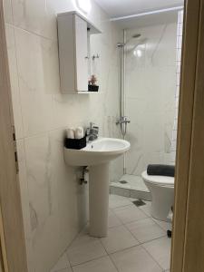 a white bathroom with a sink and a toilet at Sissy Home -Central Studio in Vathi in Samos