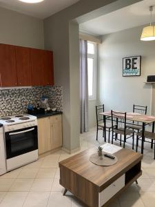 a kitchen and living room with a table and a dining room at Sissy Home -Central Studio in Vathi in Samos