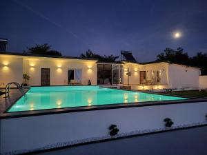 a swimming pool in a house at night at Diamona apartment lux sa pogledom na bazen in Donja Toponica