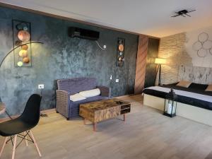 a bedroom with a bed and a couch and a table at Diamona apartment lux sa pogledom na bazen in Donja Toponica