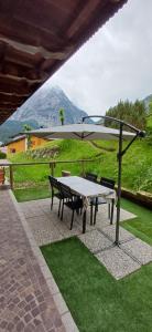 a picnic table with an umbrella on top of grass at Ai Margini del Bosco in Sappada