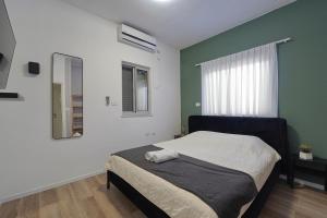 a bedroom with a bed with a mirror and a window at וילה מארי עם בריכה במגדל in Migdal +52 photos