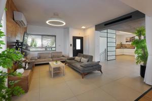 a living room with a couch and a table at וילה מארי עם בריכה במגדל in Migdal