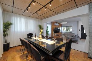 a dining room and living room with a table and chairs at וילה מארי עם בריכה במגדל in Migdal