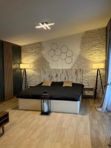 a bedroom with a large bed and a brick wall at Diamona apartment lux sa pogledom na bazen in Donja Toponica +12 photos
