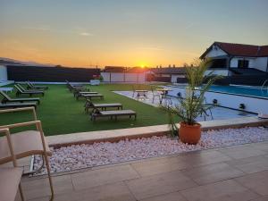 a patio with tables and chairs on a building at Diamona apartment lux sa pogledom na bazen in Donja Toponica