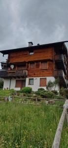a wooden house with a fence in front of it at Ai Margini del Bosco in Sappada +5 photos