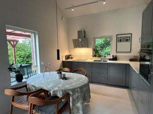 a kitchen with a table and chairs and a table and a kitchen at Gunnegårds gästhus in Fleninge