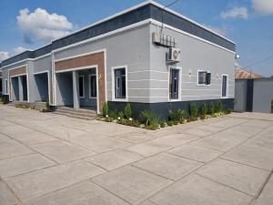 a large white building with a parking lot at Adesta Suites in Ilorin