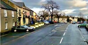 a city street with cars parked on the road at 7 Main st in Camlough