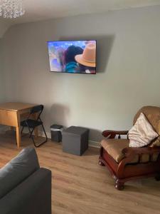 a living room with a couch and a tv on the wall at 7 Main st in Camlough