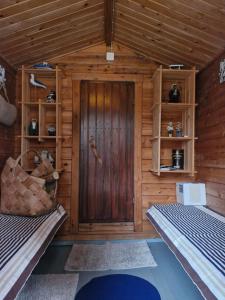 a room with a door in a wooden cabin at Peaceful riverside cottage with sauna in Myllykylä