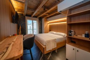 a bedroom with a bed and a desk and a table at Hosteria Pastor in Aranda de Duero