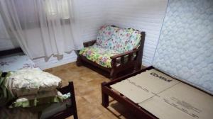 a room with a chair and a table and a box at Chácara Pousada in Juquitiba