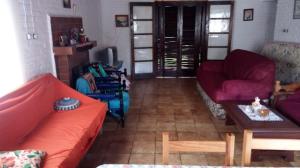 a living room with a red couch and a table at Chácara Pousada in Juquitiba