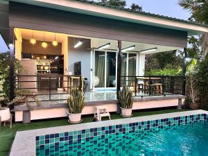 a house with a swimming pool next to a house at ฟ้ารีสอร์ต FAH Resort in Ban Nong Khang