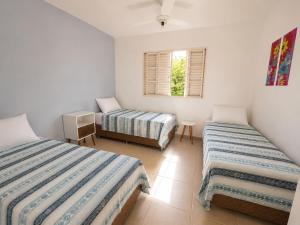 a bedroom with two beds and a window at Pousada Mais Cacau in Itu