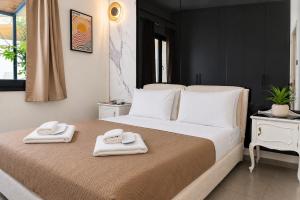 a bedroom with a large bed with towels on it at Kayia City Garden, Luxury Suite with Private Garden in Heraklio