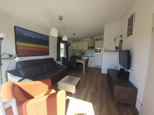 a living room with a couch and a kitchen at De Blenck 69 in Callantsoog +3 photos