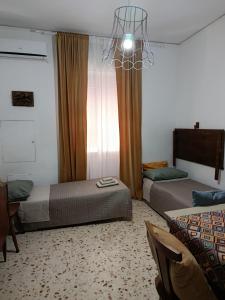 a bedroom with two beds and a chandelier at My tiny house in Salerno +12 photos