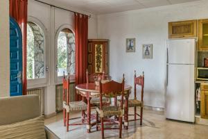a kitchen with a table and a white refrigerator at Art- Apartamentos Revilla Tacke E in Empuriabrava