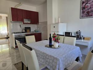 a kitchen and dining room with a table with flowers on it at Apartman Humac in Otočac