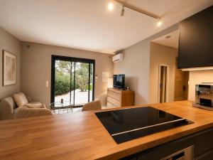 a kitchen with a counter top and a living room at La petite maison in Mougins