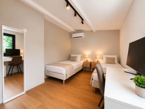 a bedroom with a bed and a desk with a computer at La petite maison in Mougins +19 photos