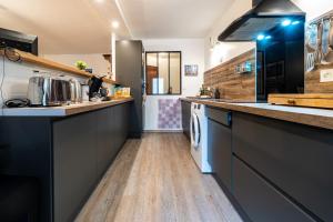 a kitchen with black cabinets and a wooden floor at Appartement Cool Montagne in Briançon